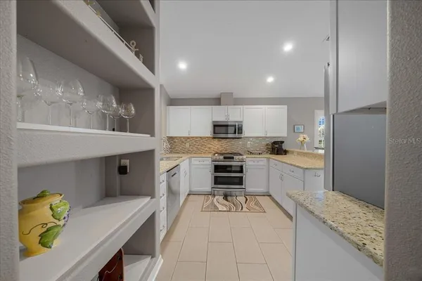 a kitchen with stainless steel appliances kitchen island granite countertop a refrigerator and a stove top oven