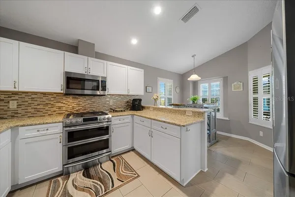 a kitchen with granite countertop a stove sink and cabinets