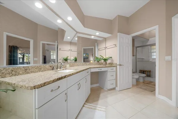 a spacious bathroom with a granite countertop sink mirror and toilet