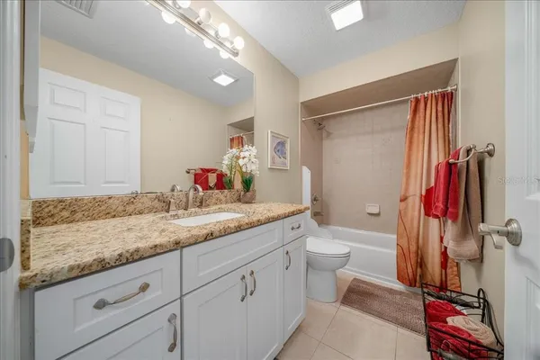 a bathroom with a granite countertop sink a toilet and a shower