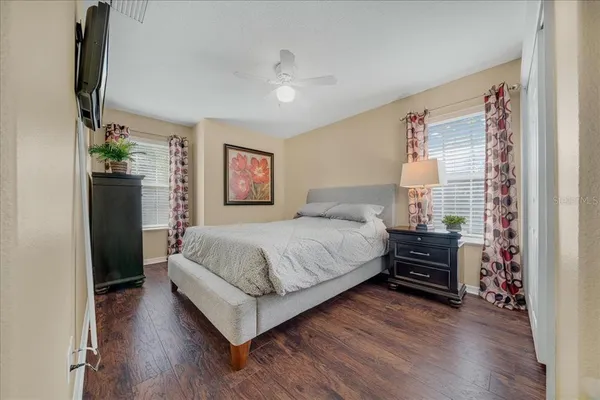 a spacious bedroom with a bed and a flat screen tv
