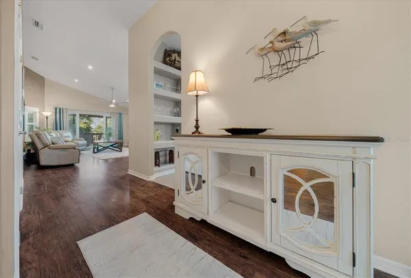 a hallway with white cabinets and wooden floor