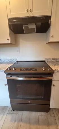 a stove top oven sitting inside of a kitchen
