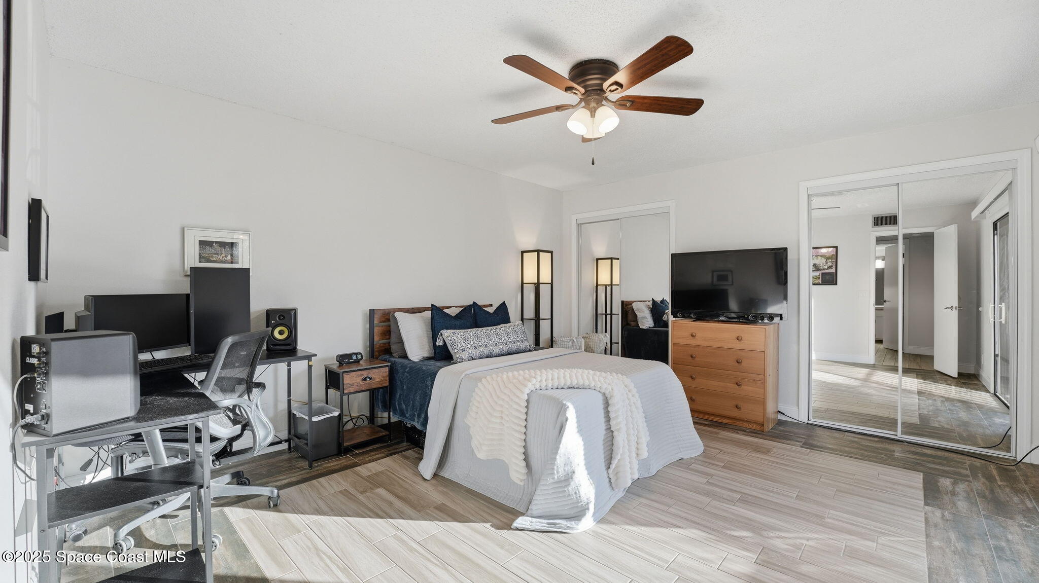 1511 Erin Court Palm Bay, FL 32905 - Photo 19 of 32 a bedroom with a bed a large window and a flat screen tv