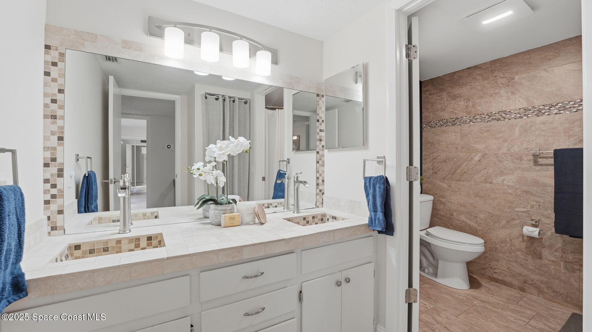 1511 Erin Court Palm Bay, FL 32905 - Photo 23 of 32 a bathroom with a double vanity sink mirror and toilet