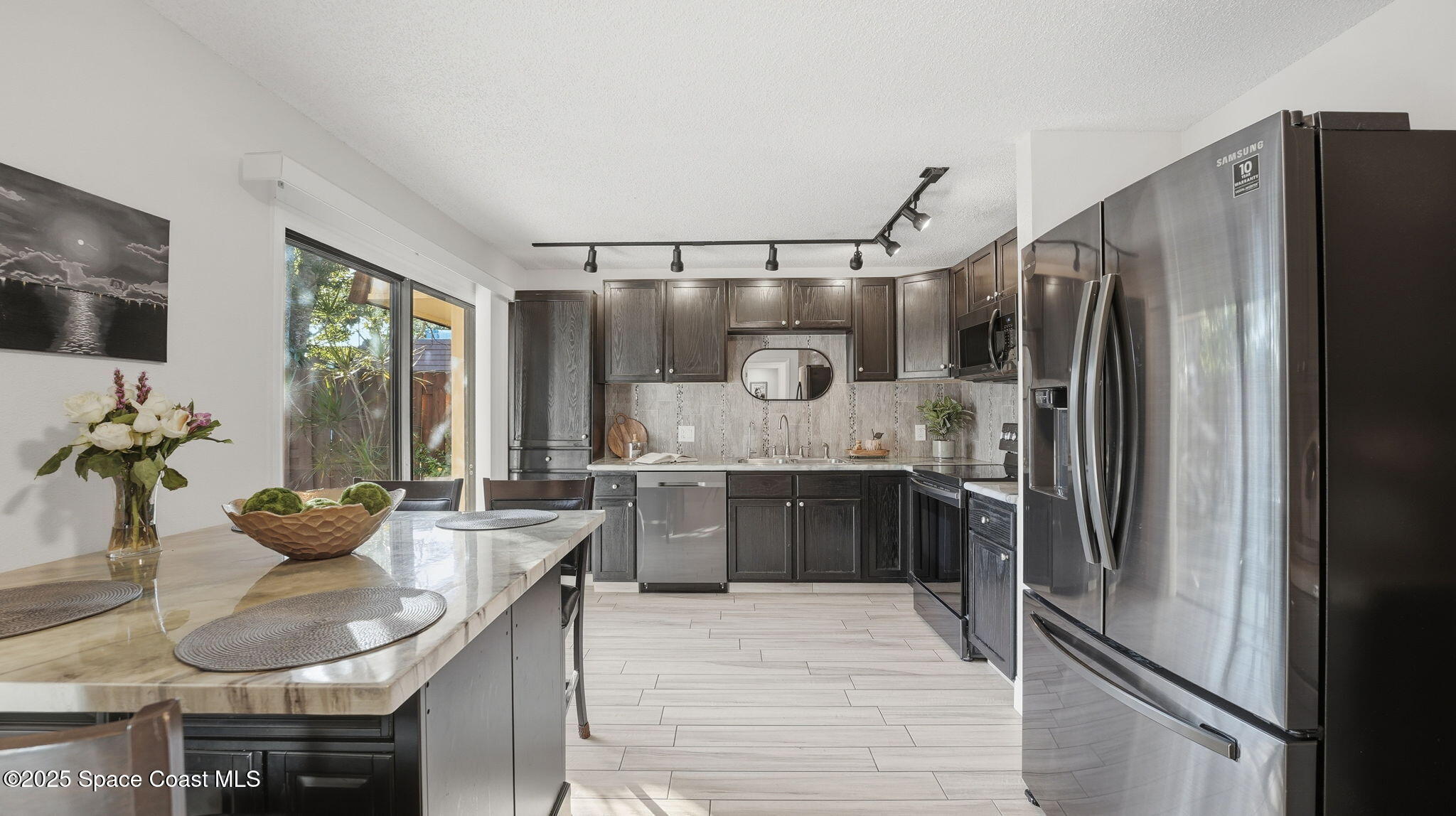 1511 Erin Court Palm Bay, FL 32905 - Photo 9 of 32 a kitchen with stainless steel appliances granite countertop a refrigerator and a sink