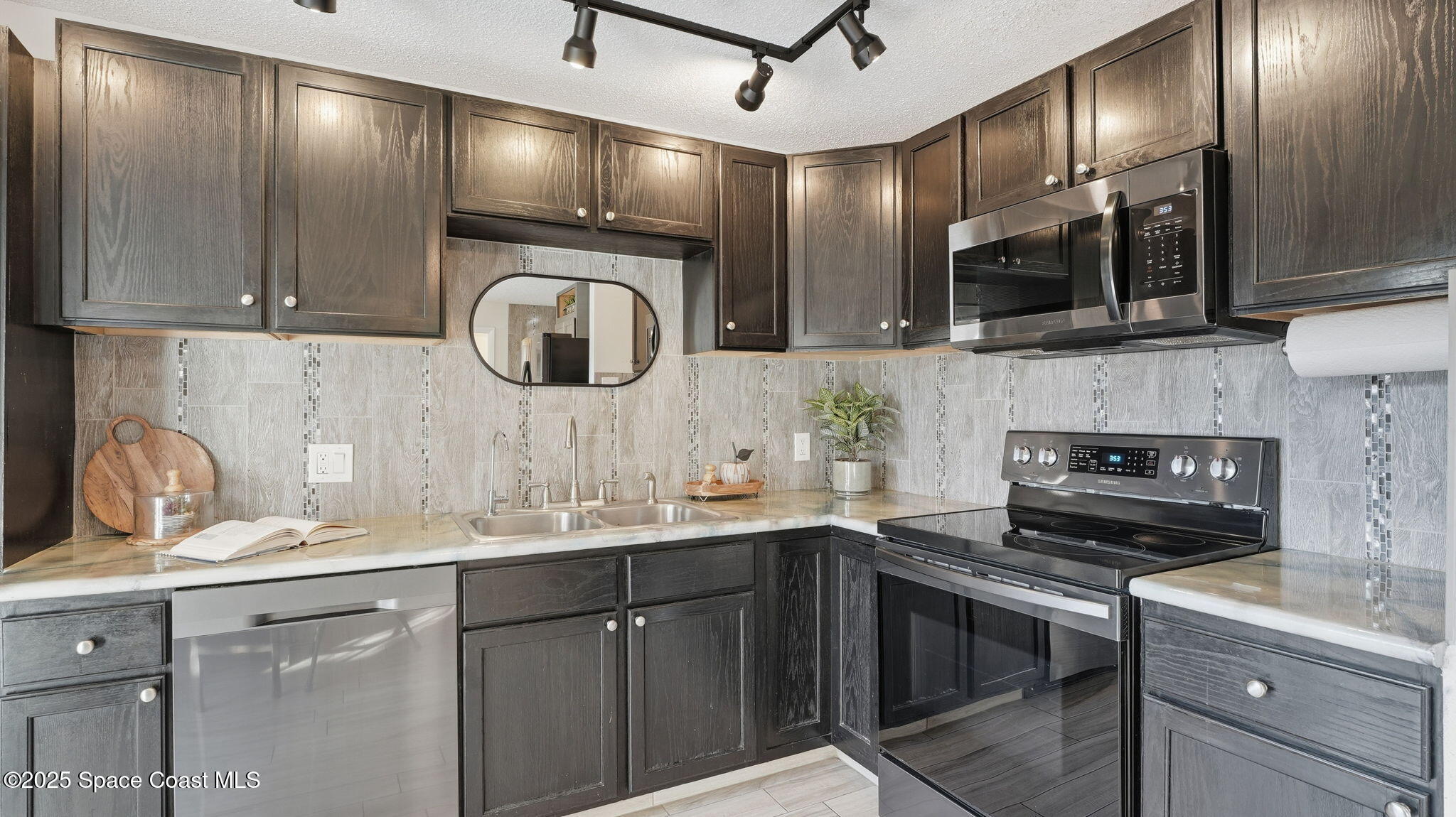 1511 Erin Court Palm Bay, FL 32905 - Photo 10 of 32 a kitchen with stainless steel appliances granite countertop a sink and a microwave