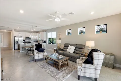 a living room with furniture and view of kitchen