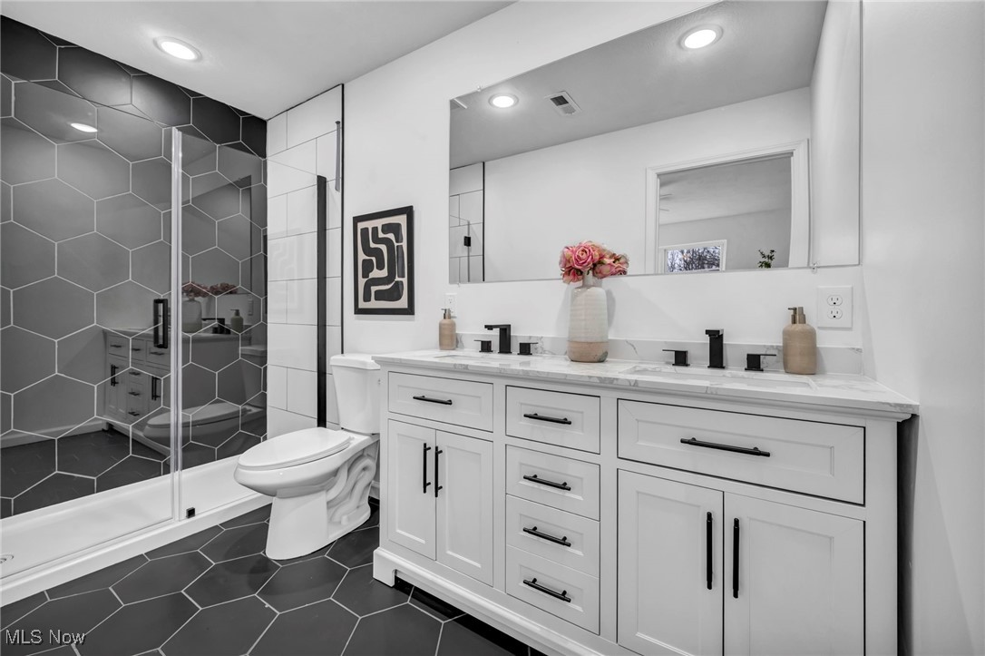 3734 Pennington Road Cleveland, OH 44120 - Photo 24 of 45 Bathroom featuring double vanity, dark tile patterned floors, a stall shower, and recessed lighting