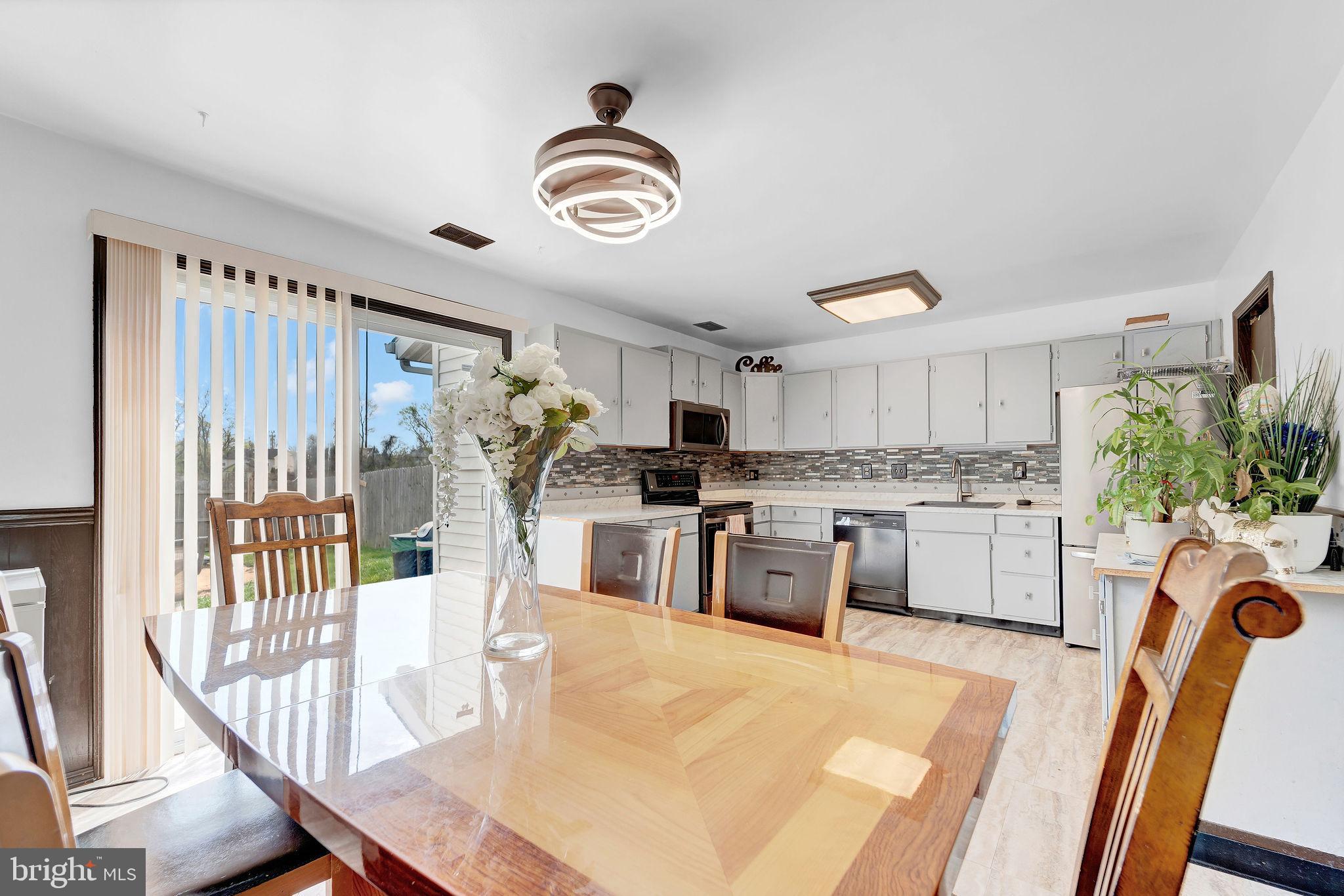 6 Transom Court Elkton, MD 21921 - Photo 13 of 33 a kitchen with stainless steel appliances granite countertop a stove top oven a sink a dining table and chairs