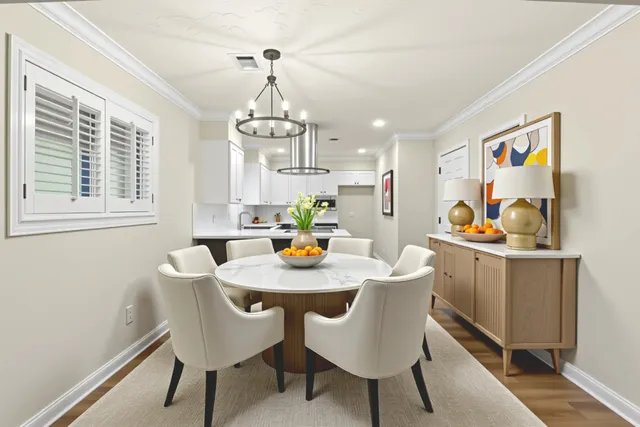 a view of a dining room with furniture a chandelier and wooden floor