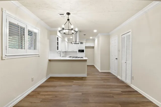 a view of large kitchen with cabinets and wooden floor