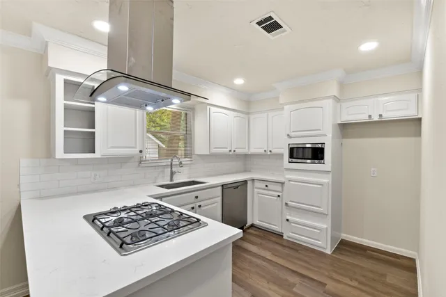a kitchen with white cabinets and appliances