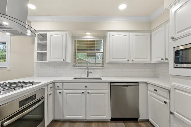 a kitchen with white cabinets and appliances
