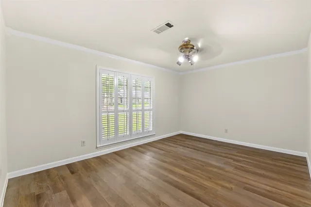 wooden floor in an empty room with a window