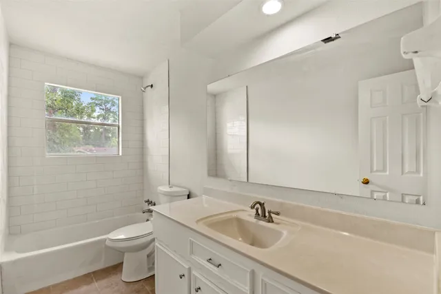 a bathroom with a granite countertop sink a toilet and a bathtub