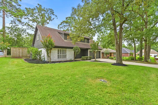 a view of a house with a yard and a tree