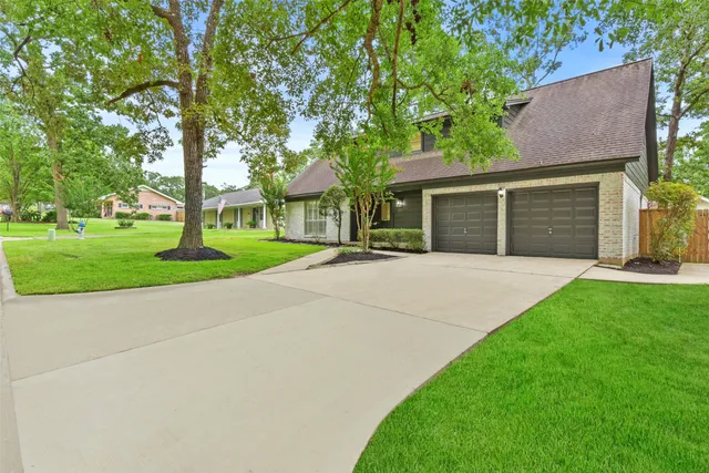 front view of a house with a yard and an trees