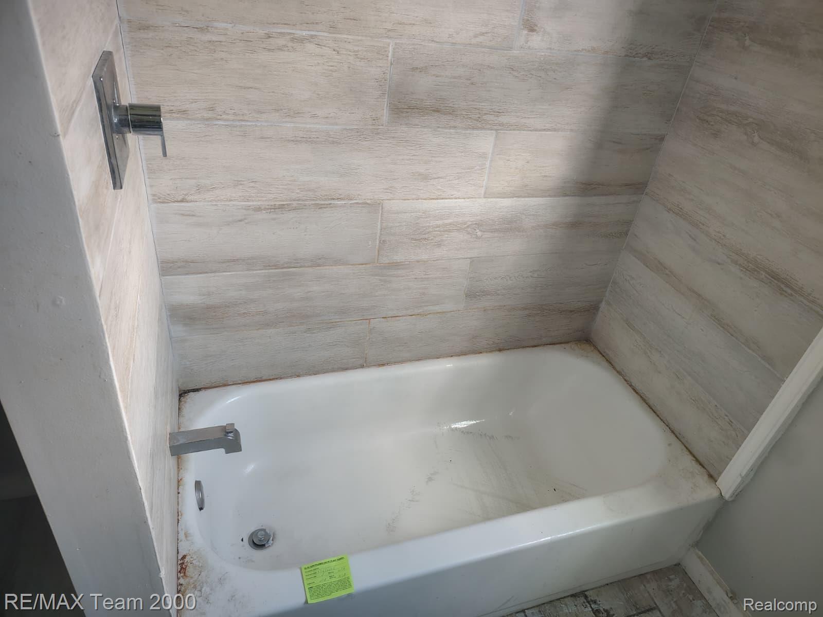 8860 Appoline Street Detroit, MI 48228 - Photo 33 of 45 Bathtub with light-colored tile surround and chrome fixtures