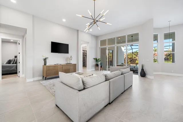 a living room with furniture a ceiling fan and a flat screen tv