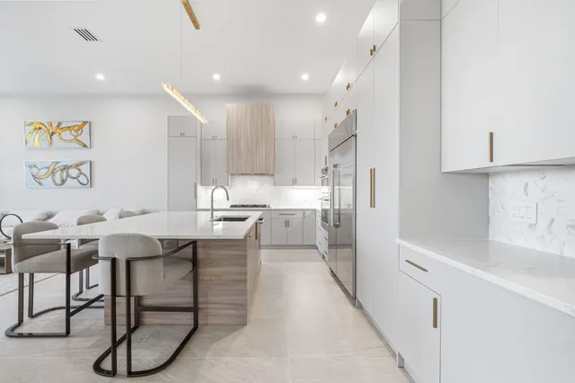 a kitchen with a table chairs refrigerator and microwave