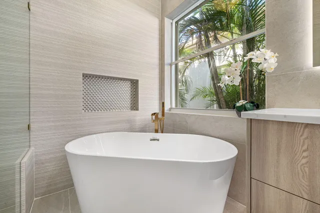 a bathroom with a double vanity sink toilet mirror and bathtub