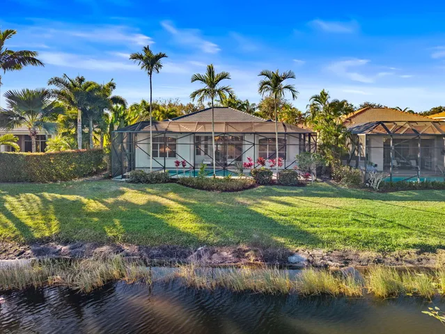 a front view of a house with a big yard and a large tree