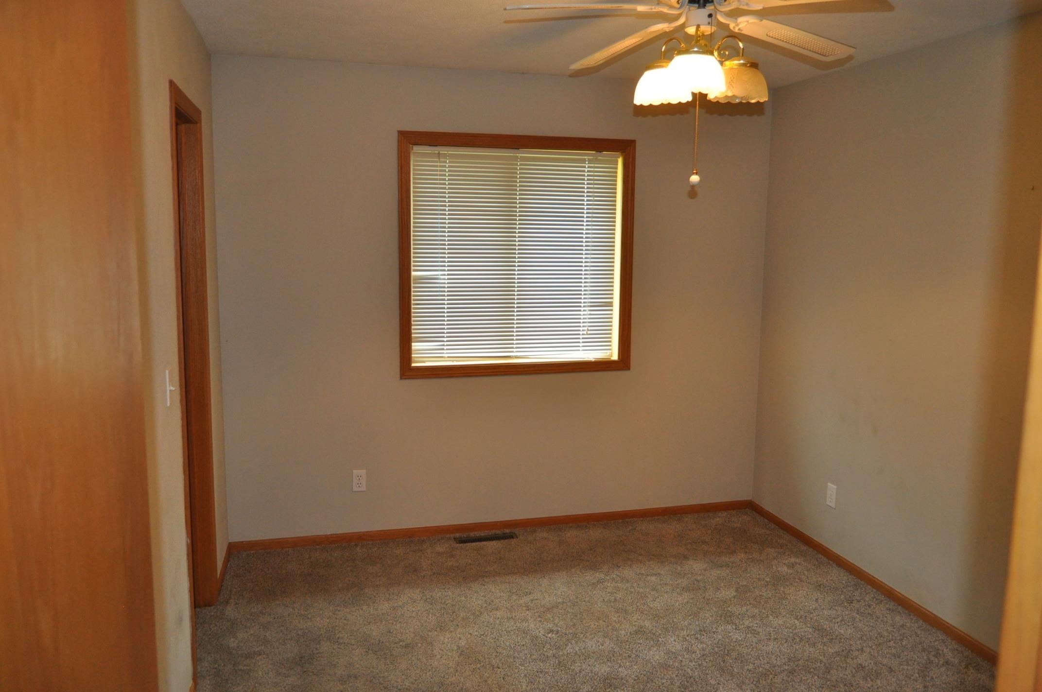 135 Fieldcrest Lane Cedarville, IL 61013 - Photo 17 of 45 an empty room with a chandelier fan and windows