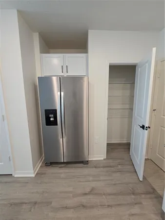 a view of an empty room with wooden floor and a cabinet