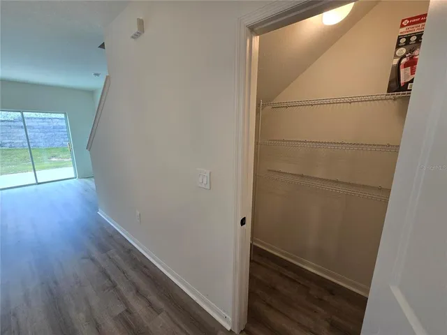 a view of empty room with wooden floor