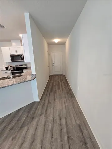 a view of a kitchen with wooden floor and electronic appliances