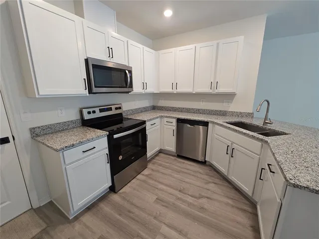 a kitchen with a sink stove and microwave