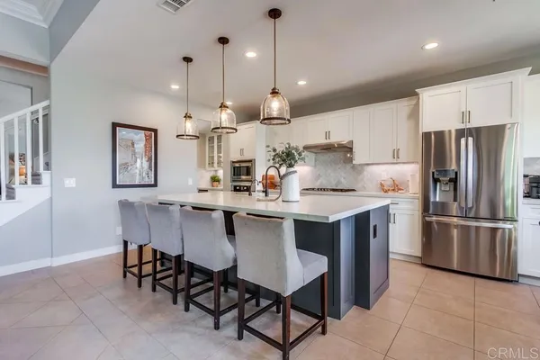 a kitchen with stainless steel appliances a dining table and chairs