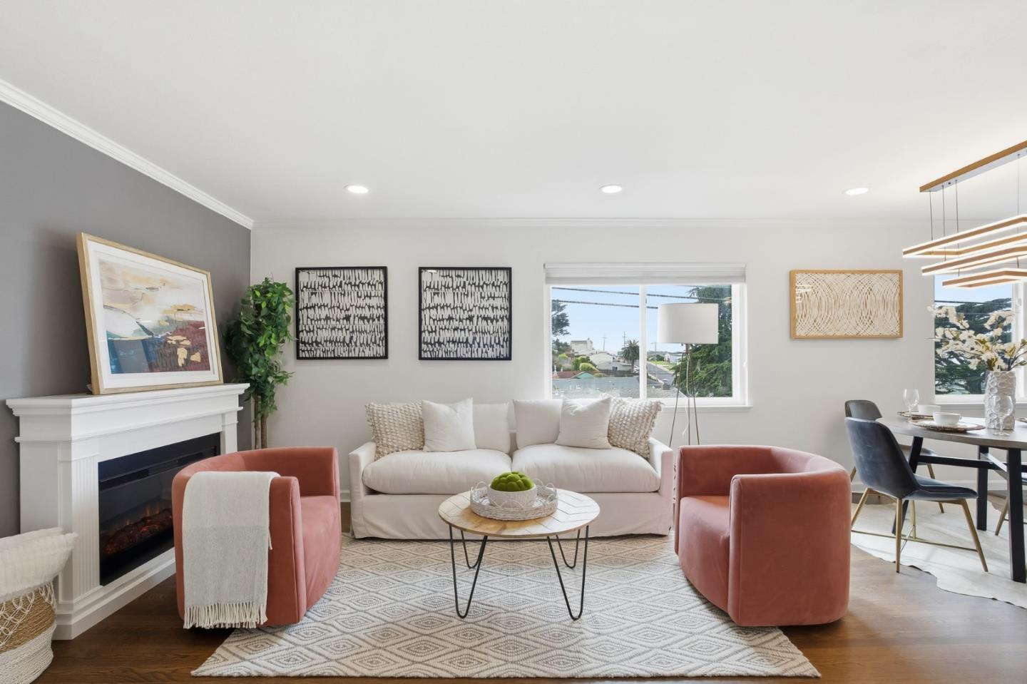 a living room with furniture a fireplace and a large window