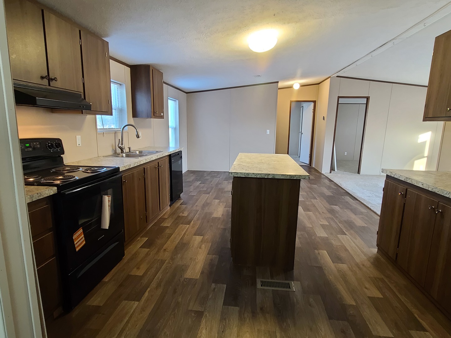303 Seba Street Hurst, IL 62949 - Photo 7 of 13 a kitchen with granite countertop wooden floors a stove and a refrigerator