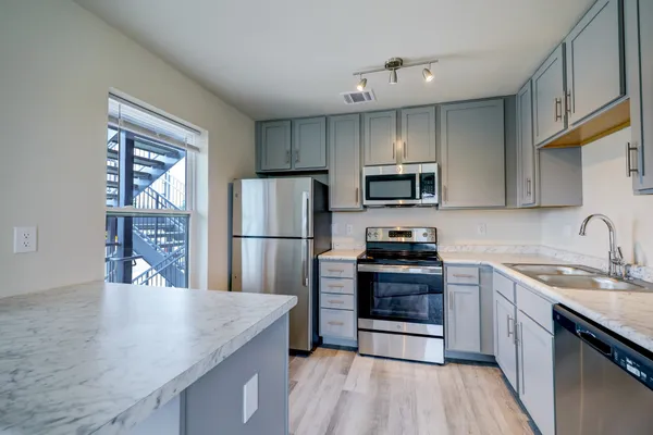 a kitchen with a sink a microwave a refrigerator and cabinets