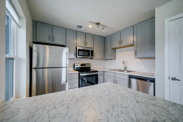a kitchen with a refrigerator stove microwave and sink