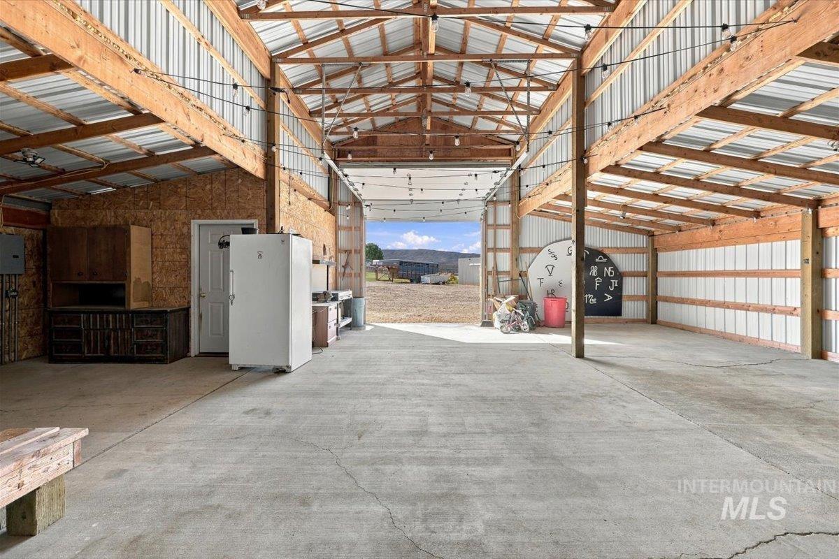 18026 Briar Creek Road Murphy, ID 83650 - Photo 35 of 50 White-paneled barn with black trim and a large black garage door