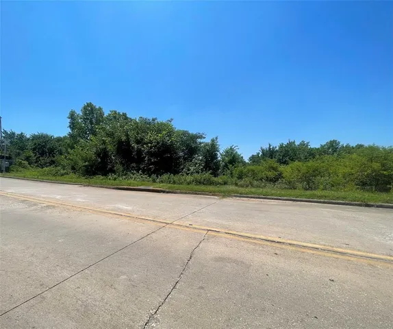 a view of a field with trees in the background
