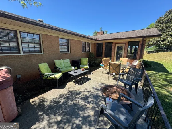 a view of a house with backyard sitting area and furniture