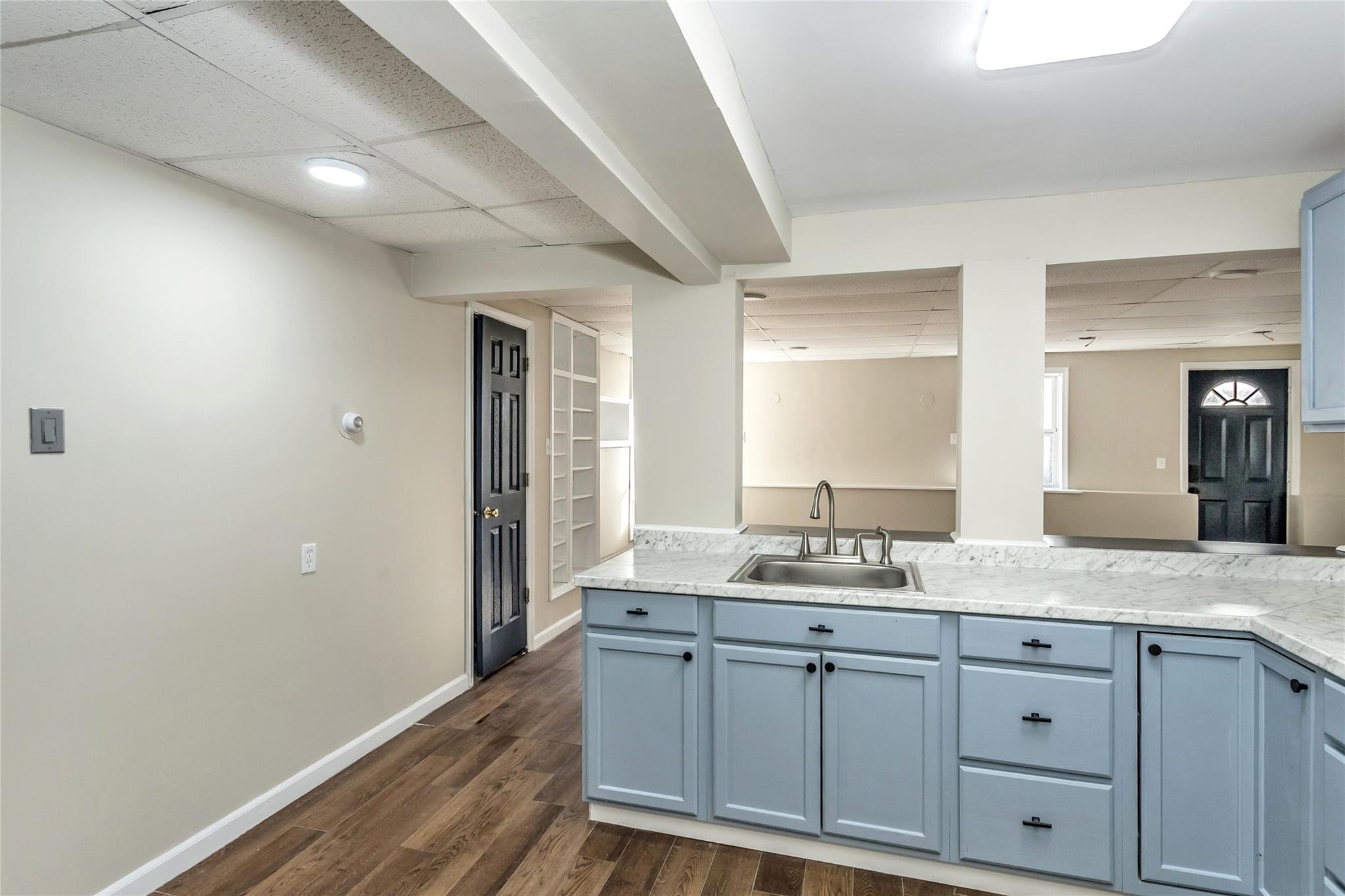 9 Bayberry Road Wading River, NY 11792 - Photo 14 of 17 Kitchen featuring blue cabinets, a paneled ceiling, dark hardwood / wood-style flooring, and sink