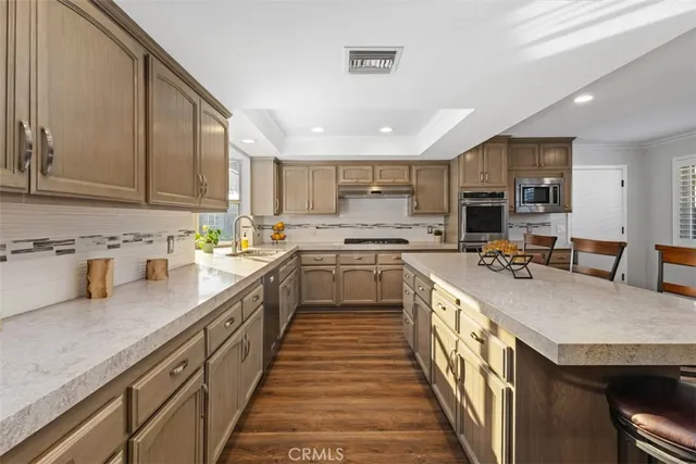 a kitchen with stainless steel appliances granite countertop sink stove top oven and cabinets