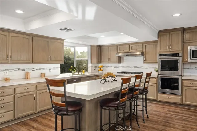 a kitchen with a table chairs microwave and cabinets