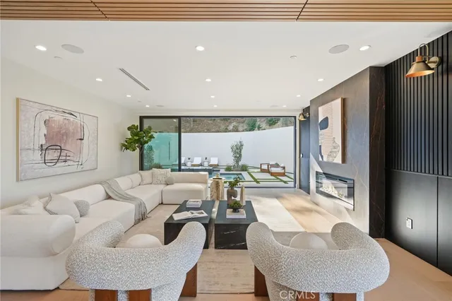 a living room with furniture a potted plant and a painting on the wall