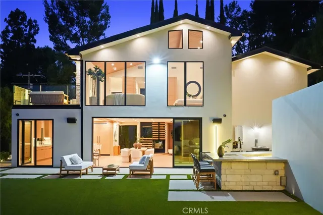 a front view of a house with swimming pool and chairs
