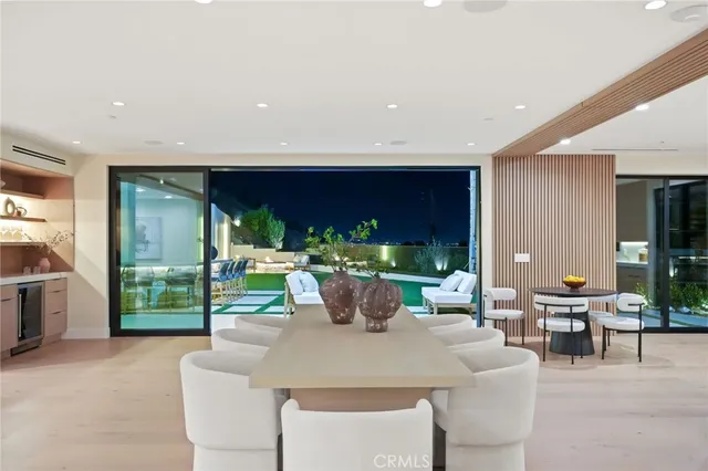 a dining room with furniture a chandelier and a floor to ceiling window