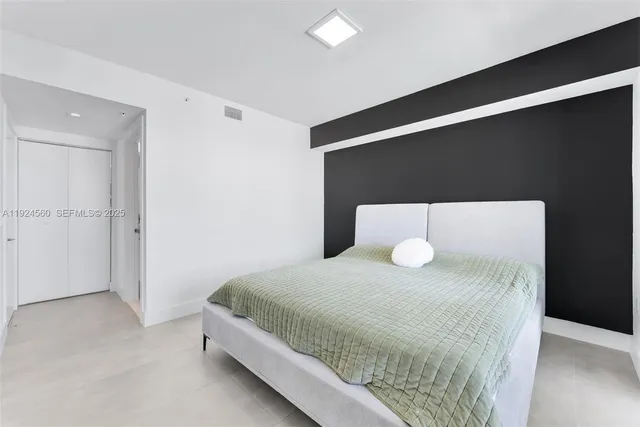 a bedroom with a bed and a night stand