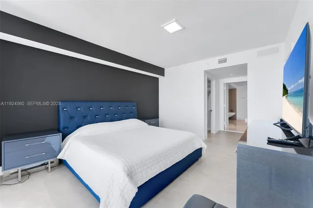 a bedroom with a bed and a flat screen tv