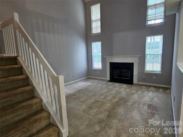 a view of empty room with fireplace and windows