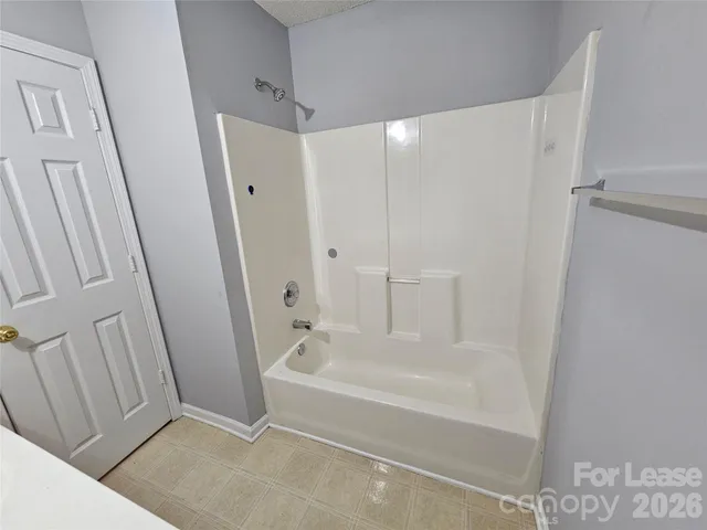 a white bath tub sitting next to a shower